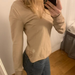 Tröja - Beige diseltröja med v-ringning fram och bak!💛Har snygg detalj på sidan och knappt använd! (Har likadan i svart oxå) (storleken är lite oklar men skulle säga att den passar xs-m)