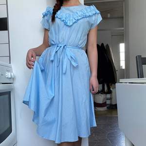 En fin blå vintage midi längd klänning som påminner om ”Alice in the Wonderland”. Har fina rysch och kan knyttas vid midjan. Perfekt till vår och sommaren. Jag är 150cm som referens😊. Har fler drömlika klänningar, kika på min profil✨.