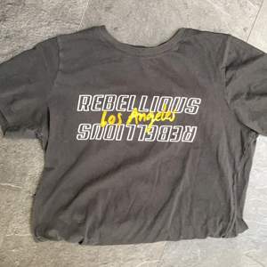 Pösig svart T shirt från Gina tricot med gul och vit text. I bra skick