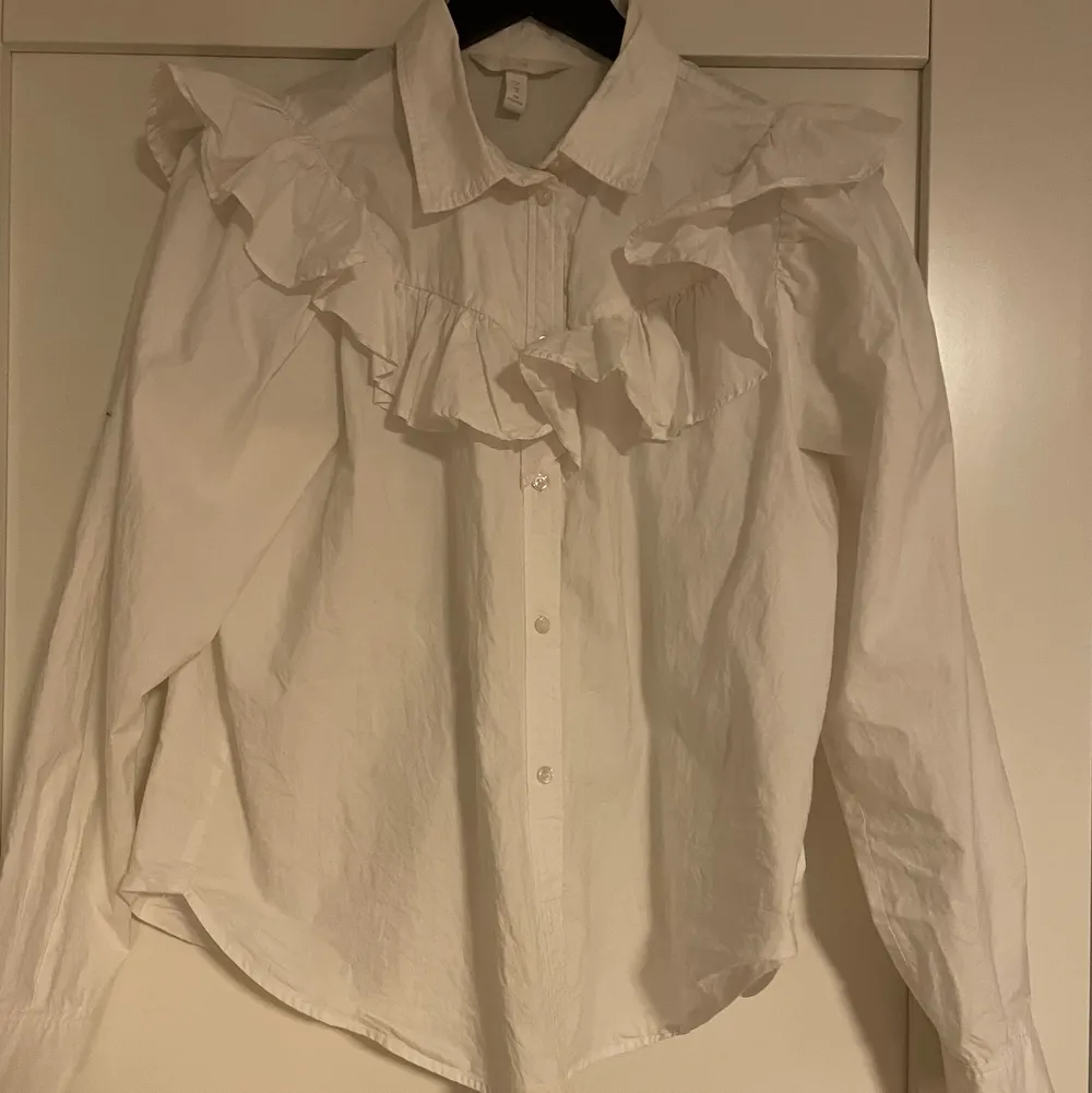 En vit volang skjorta från hm i storlek M! Skulle säga att den passar en S lika bra som en M. Skjortor.