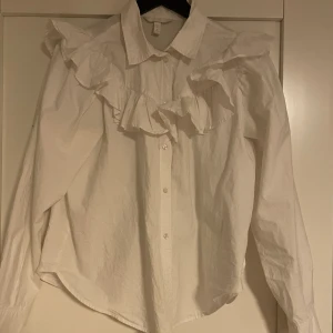 Vit skjorta - En vit volang skjorta från hm i storlek M! Skulle säga att den passar en S lika bra som en M