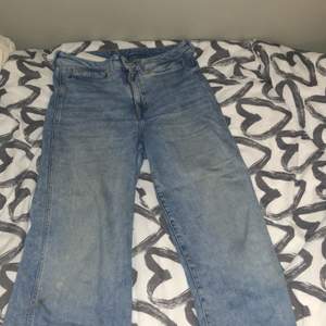 Ett par blåa h&m jeans, vida, ca 89 cm från knappen till byxbenets ände.