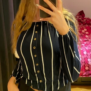 Mörkblå blus med vita ränder - Mörkblå blus med vita ränder med knappar i mitten. Knapparna går inte att öppna upp. Använt fåtal gånger. Fint skick.