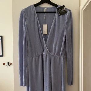 KLÄNNING NELLY - Superfin plisserad ljusblå omlottklänning från Nelly. Helt ny med prislapp. 