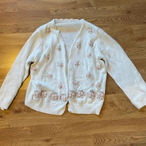 Blommig kofta - Vit kofta med broderade blommor☘️ står ingen storlek men skulle säga XS-M  ( armarna är ganska korta) frakt tillkommer 
