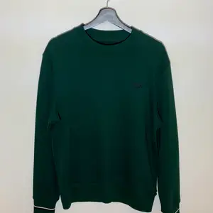 Nyskick Fred Perry sweatshirt i mörkgrönt. Prövad 1-2 gånger. Inga fläckar eller skador samt aldrig tvättad. Bomull och polyester. Nypris 1100kr.