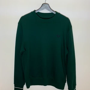 Fred Perry sweatshirt i storlek M - Nyskick Fred Perry sweatshirt i mörkgrönt. Prövad 1-2 gånger. Inga fläckar eller skador samt aldrig tvättad. Bomull och polyester. Nypris 1100kr.