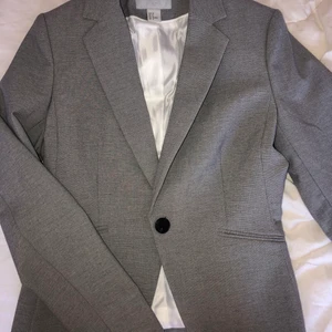 H&M grå kavaj strl 38 HELT NY - En kavaj ifrån H&M som endast är använd en gång. Den är helt ny och i väldigt bra skick, inga fläckar osv, passar S och M. Pris kan diskuteras!