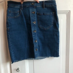 Jeanskjol - Jeanskjol med fakeknappar, dragkedja på sidan. 