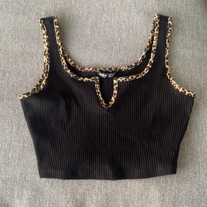 Svart topp från SHEIN 🤎 - En svart topp med leopard tryck längst kanterna . Tycker den är assnygg men säljer pga för stor. Skulle därför säga att den är stor i storleken. Köpare står för frakt.🤎