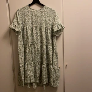 Klänning ifrån SHEIN, strl L - En söt klänning ifrån SHEIN som tyvärr va lite tight i armarna för mig, supersöt annars med grön/vita blommor på med knapp bak. Helt oanvänt endast provat en gång, finns dock ingen lapp på eftersom de skickar utan. 