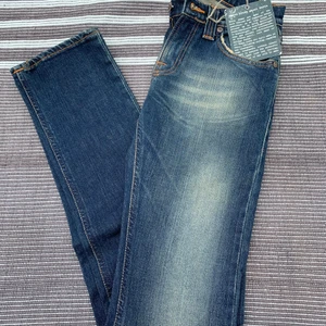 Nya oanvända Nudie Jeans stl 26/34 - Nya oanvända Nudie Jeans modell Super Slim Kim med etiketterna kvar, stl 26/34. Köparen står för frakt. 
