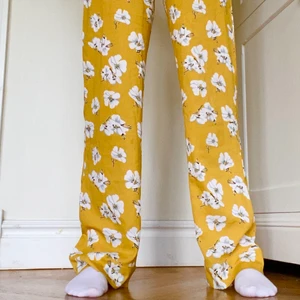 Sommarbyxor  - Ett par jättefina gula sommarbyxor med blommor köpta på Afound i Stockholm. Endast använda ett fåtal gånger (nyskick). Jag är 164 cm lång och dom går över skorna på mig. Dom är inte genomskinliga utan har ett tunnare gult tyg innanför som man kan se på sista bilden. Köpta för 300kr. Köparen står för frakt :) 