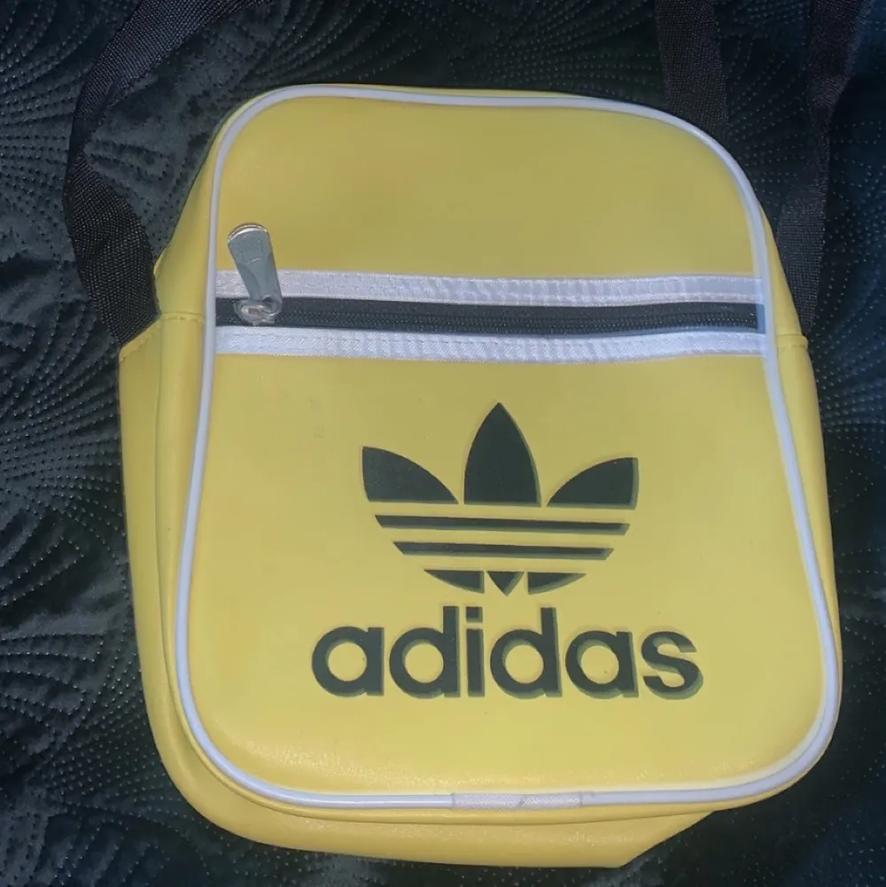 Adidas - en gul väska köpt för några år sen, aldrig använd bara legat i garderoben. . Väskor.
