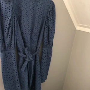 Broderad klänning  - Storlek S. Mörkblå miniklänning som markerar midjan med puffärmar, superfin!