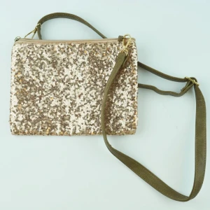 New Year🎆 by M.E.J UF - En rosa paljettväska med ett brunt justerbart axelband. Väskan passar till alla festliga sammanhang och piffar upp din outfit. 