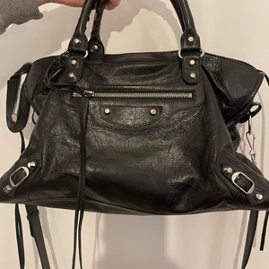 Balenciaga väska - Säljer min balenciaga city bag. Den är svart med silvriga nitar. Dustbag, äkthetsbevis och spegel, allt följer med. Nypris 18 000kr. Perfekta storleken, får plats med allt.