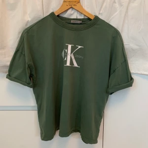 Calvin Klein T-shirt - Grön t-shirt från CalvinKleinJeans. Modellen är lite croppad och ”boxig”. Stl L (Men skulle säga passa XS-M beroende på vilken passform man vill ha). 