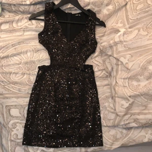 Perfekta nyårsklänningen! - Svart klänning med paljetter och utskurna detaljer under bröstpartiet, glittrar superfint vilket jag tycker passar bra till nyår. Passar inte mig så därför får även den gå vidare, skicket är bra! Storlek är small. 