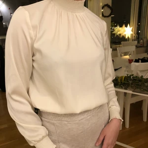 Cream färgad Gina Tricot blus stl 38 - Cream färgad Gina Tricot blus stl 38🎄 Väldigt lite använd tyvärr pga fel storlek så i princip ny. Passar bra till både byxor 👖 och kjol👗 perfekt som Jul 🎄 och Nyårs 🎉 outfit..