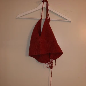 Virkad topp - Egenvirkad topp, roströd. Triangeltopp med knytning i nacken och snörning i ryggen. Passar lite olika storlekar beroende på hårt/löst man knyter i ryggen.