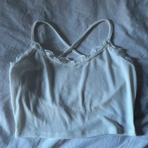 Vit topp strl M/S - Helt ny vit topp i storlek S/M. Med spets upptill och korsad i ryggen. Aldrig använd! Frakt 26kr 🥰