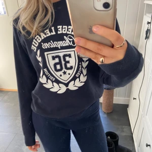 College tröja - Marinblå college tröja från Nelly! Superfin och är i väldigt bra skick! Passar mig som vanligtvis har s, säljer för 200kr + frakt på 66kr