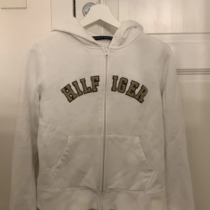 Tommy Hilfiger zip up hoodie  - En vit zip up hoodie från Tommy Hilfiger i storlek M men skulle mer säga att den är en XS-S, köparen står för frakten 💞