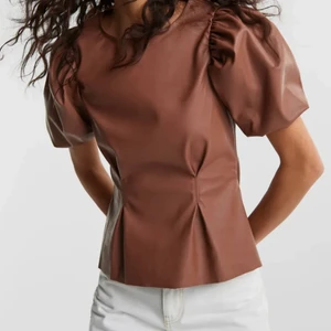 Topp i läderimitation - Säljer denna söta topp i en fin brun läderimitation, säljs då den inte används, köpt för 299kr säljer för 70kr 🤎