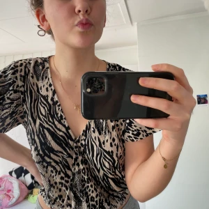 Djurmönstrad topp - Croppad topp med zebra och leopard mönster, med lite vidare ärmar. 