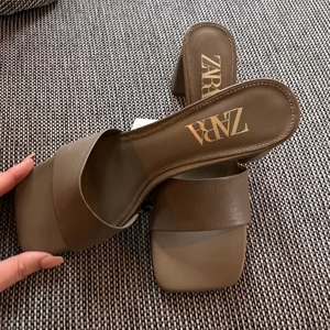 Square sandals från ZARA - 🤎Dem PERFEKTA klackarna från Zara🤎. Äger i alla färger som såldes i sommar☺️ dessa är i mörk NUDE. Har aldrig använt dessa så säljer dem vidare till någon som kommer garanterat bo i dessa i vår/sommar. Går till ALLT. Såldes slut i sommar på någon vecka. Kostade 559kr nya. Lapp finns kvar. Dessa är i storlek 40 men har vanligtvis 39