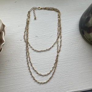 Halsband i guld.  - Halsband med tre kedjor som sitter ihop. Guldfärgad och oanvänd. 