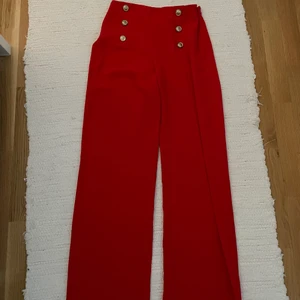 Röda byxor  - Mina häftigaste byxor från River island. Köpt i London. Säljes pga för stora för mig. Guldiga knappar fram.