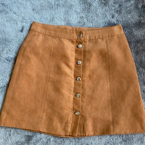 Kjol - Kort mockakjol i storlek 40 men är mer om en 38:a 