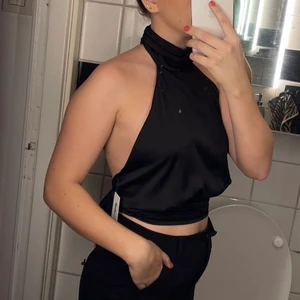 Topp med öppen rygg  - Säljer denna populära festtopp med öppen rygg och halterneckdesign! Säljs i fint skick, endast använd en gång🌼 strl 36. Nypris 299kr!