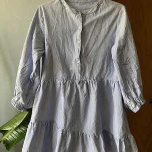 Supergullig sommarklänning - En supergullig randig sommmarklänning. Endast använd en gång. Volangen i kjolen är lite asymmetrisk. Vet inte vad märket är eller storleken då det inte finns någon lapp i plagget. Den passar på mig som vanligtvis har XS och som är kort. Inköpt second hand. 