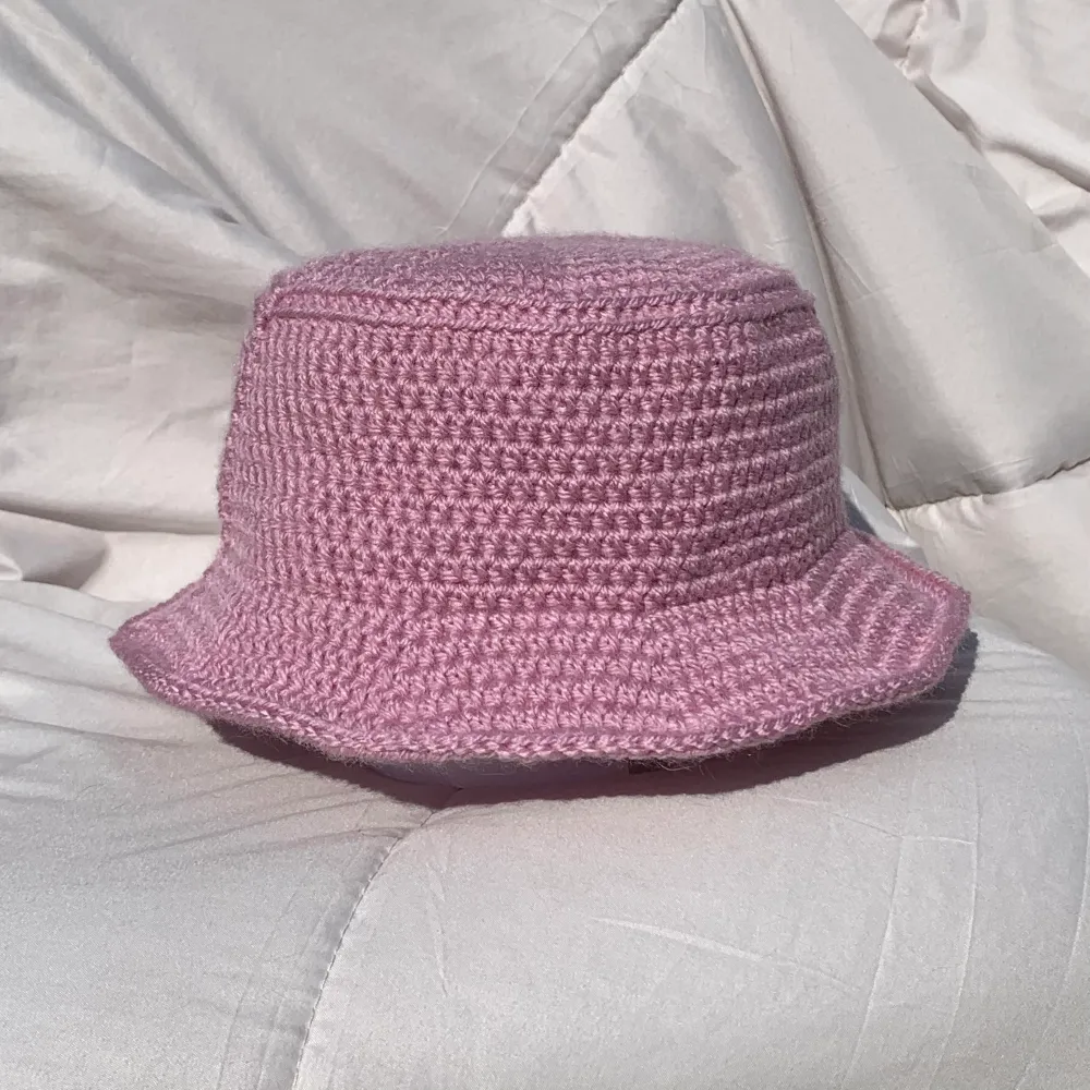 Rosa, handgjord fiskehat. 100% akryl, tvättas i 40. Just denna hatt har mindre rem än övriga för ett mer ”feminint” utseende (vill du ha vanlig rem, skriv till mig) . Betalning via safepay/swish. Stickat.