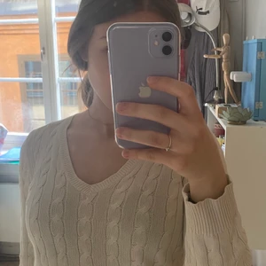 Fin Ralph Lauren tröja - Superfin ribbstickad tröja från Ralph Lauren🪐 tröjan är cremefärgsd och har en ganska djup v-ringning! Tröjan är använd men i ett mycket bra skick bortsett från en blek mascarafläck (bild 3). Köparen står för frakten