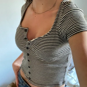 Randig t-shirt - Kroppad randig t-short med knappar från monki. Möts upp eller står köpare för frakt, 45kr ej spårbart eller 66kr spårbart