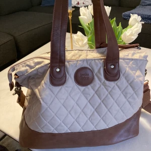 Skötväska Petite Cherie - Skötväska, använd 1 år ca, som ny utvändigt, finns en liten svart fläck invändigt.. skicka meddelande vid intresse!