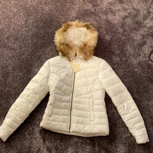 Vit dunjacka - Säljer en vit fin dunjacka från Intersport i storlek 34 där ordinarie priset var 699 kr. Aldrig använt, prislappen är kvar. Jag säljer den för 150kr 
