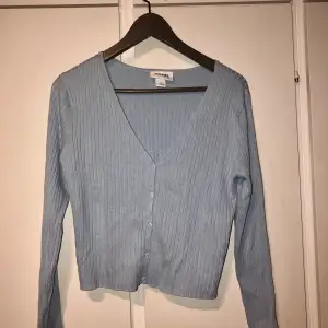 Ljusblå topp från Monki. Storlek XL, men tröjan är fortfarande kort över magen. Väldigt skönt material och kan användas både som kofta eller tröja. Använd en gång.