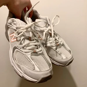 New Balance sneakers, vit, silver,orange - New Balance sneakers i nyskick, endast testat dem. True to size. Snygga och sköna skor som tyvärr inte kommer till användning! Vita med silver och orangea detaljer. Slutsålda på de flesta hemsidorna i mindre storlekar. Passar folk med stl 38. 