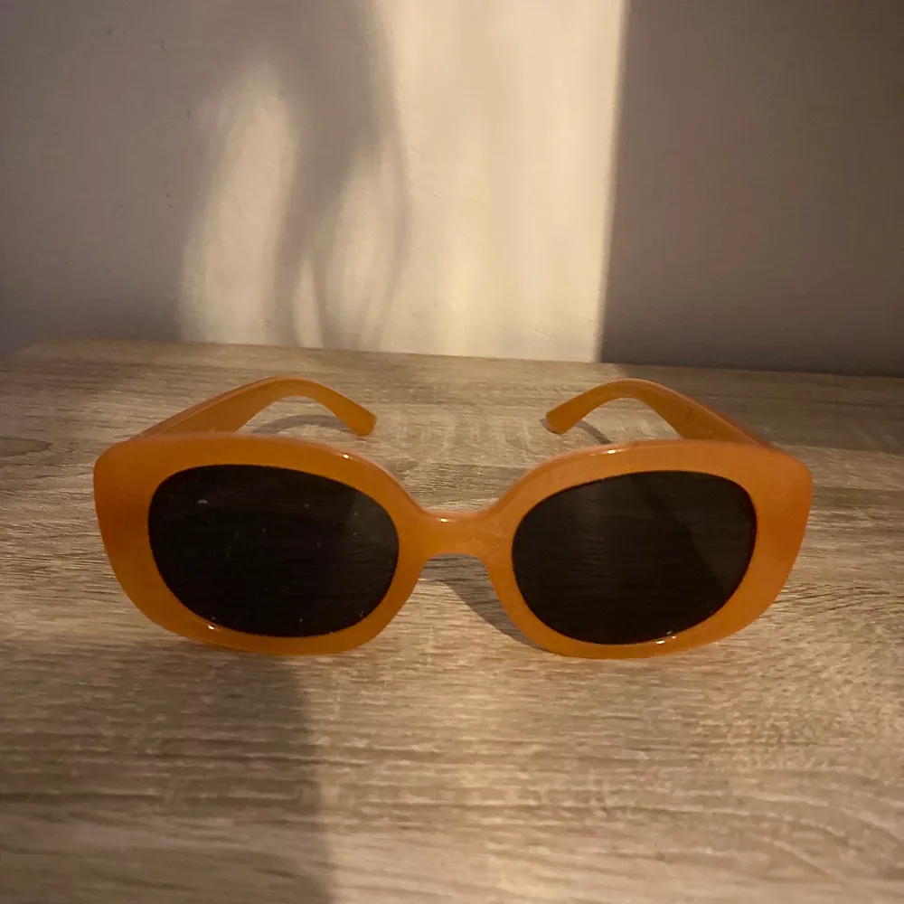 Orangea solglasögon i retro stil. Bling på sidan. . Accessoarer.