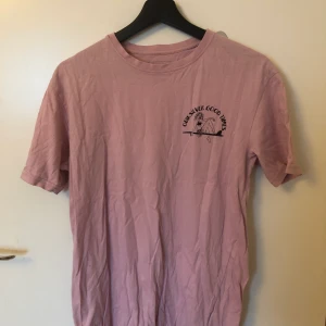 T-shirt storlek S - En assnygg rosa t-shirt storlek S. Den har ett mindre tryck på framsidan och ett större likadant på ryggen. 