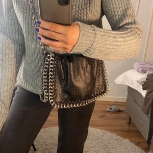 Svart väska  - Svart väska från tiamo, går att justera att ha som på bilden eller kortare hängandes på axeln 