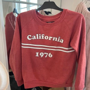 Sweatshirt med tryck från bik bok - Sweatshirt från bik bok i färgen rost röd, tryck california, väldigt snygg passar perfekt till blåa jeans!! Storlek XS 