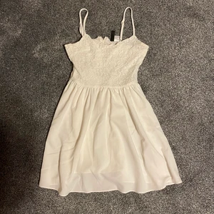 Vit klänning från HM - En fin vit klänning från HM, köptes 2015 tror jag, så den finns inte att köpa i butik längre. Välanvänd men i bra skick. Se sista bilden för att se det som gör att den inte är i väldigt bra skick, dock inget som syns när klänning är på! :) Storlek 34. Kan mötas upp annars står köparen för frakten, priset för frakten beror på vad för påsar det finns att välja mellan på PostNord men mellan 60-70kr. Finns på fler sidor. 