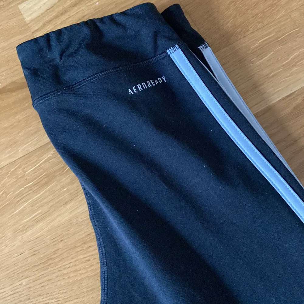 Sköna svarta Adidas  träningsbyxor med en vit rand på sidan. Även väldigt sköna för att ha som inne mys byxor.. Jeans & Byxor.