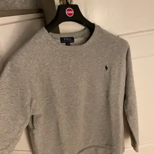 Hej jag säljer denna gråa sweatshirt ifrån Ralph Lauren! Storleken 14-16 då den är köpt som barnstorlek men de motsvarar xs. Skick 9/10! använd endast fåtal gånger inköpt på kidsbrandstore för några år sen. Kom privat för fler bilder eller frågor!